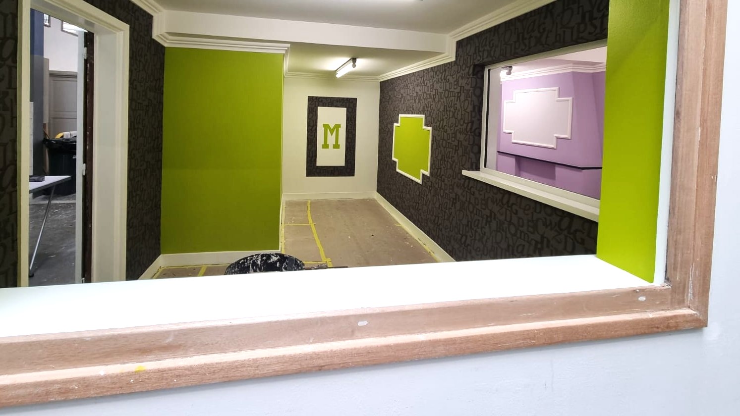 Travaux de peinture intérieure : murs vert anis et cadre décoratif réalisé par PHIT